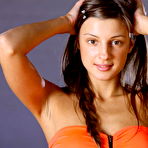 Pic of Malena, with her tempting gaze, beautiful puffy breasts, and slender physique strips her sexy orange dress baring her delectable assets in front of the camera.