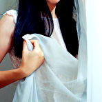 Pic of Skinny brunette dressed in white shows her smooth labia to the viewer - aMetart.com