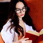 Pic of Nude Nerdy Debora A flaunts her sexy, slender body while reading on the chair.