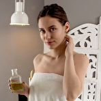 Pic of Nude Hazel slathers some massage oil on her body and starts stroking her smooth assets