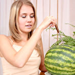 Pic of Astonishing angel is sitting on the table with a sappy red watermelon, which excited her so much that she started self-service. gallery