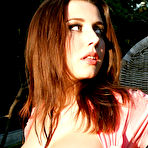 Pic of Smoking hot redhead babe with amazing boobs stripping outdoor