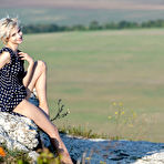Pic of Blonde teen Azshara removes a polka dot dress to pose nude on high ground
