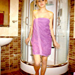 Pic of Blonde teen teases in a shower while wearing a purple bath towel