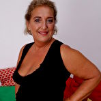 Pic of Mature housewife and her young boy toy fuck on a red chesterfield