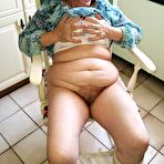 Pic of Horny granny Caro sticks a banana inside her natural pussy on kitchen chair