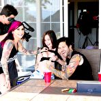 Pic of Tattooed dark haired slut in short skirt gives hot handjob during threesome