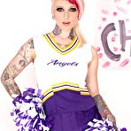 Pic of Tattooed chick Scarlet Lavey works free of a cheerleader outfit to pose naked