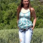 Pic of Older brunette NicolD whips down her blue jeans to piss in the tall grass
