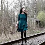 Pic of Brunette girl Lara pees on concrete blocks while walking railway tracks