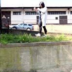 Pic of Dark-haired chick Lora pulls down her leggings to pee over a retaining wall