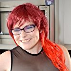 Pic of Thick redhead removes leather attire to pose nude before donning nurse garb