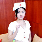 Pic of Petite Latina nurse Joana lifting top to expose small breasts