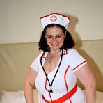 Pic of Overweight nurse removes her uniform to model nude in black panties on a bed