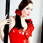 Pic of Tall woman with brunette hair models a latex bodysuit with matching red lips