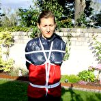 Pic of Submissive woman Sandra is tied up while wearing a raincoat in a sunny yard