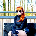 Pic of Redheaded MILF shows her tits and pussy on a bench out on a rooftop balcony