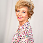 Pic of Older redhead Romana gets naked on a sofa while wearing black pumps