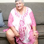 Pic of Horny Grandma Libby strips and spreads her old shaved pussy on the sofa
