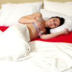 Pic of Young brunette Liz Jordan fingers and dildos her pussy on a bed