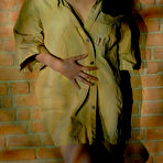 Pic of Brunette glamour model exposes herself against a brick wall in poor light